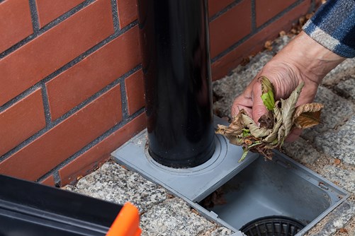 mann rensker sluk ved takrenne.jpg